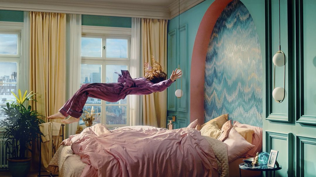 Persoană căzând pe un pat